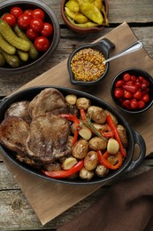 Photo of Tasty beef tongue pieces with potatoes served on wooden table, flat lay