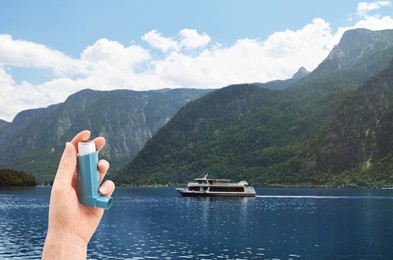 Woman with asthma inhaler near lake, closeup. Emergency first aid during outdoor recreation