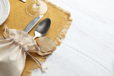 Photo of Autumn place setting with cutlery on white wooden table, closeup. Space for text
