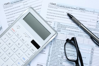 Photo of Calculator, glasses and pen on documents, flat lay. Tax accounting