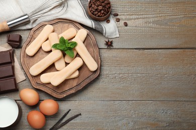 Flat lay composition with tiramisu ingredients on wooden table, space for text