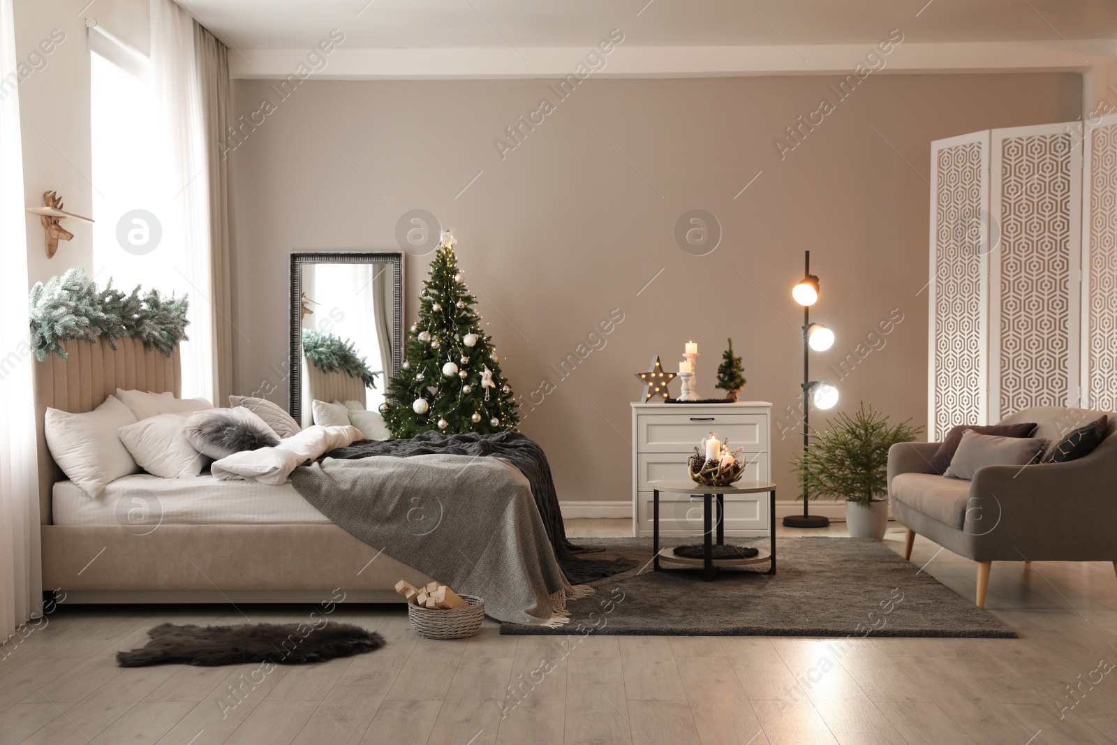 Photo of Beautiful decorated Christmas tree with fairy lights in bedroom interior