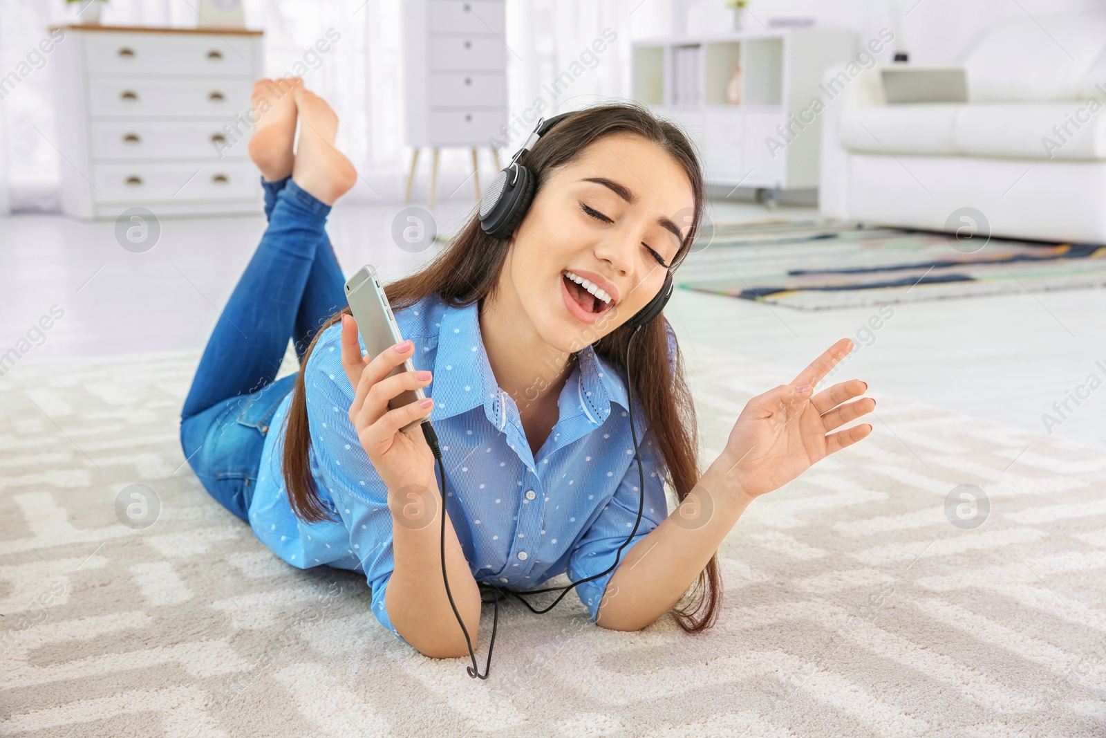 Photo of Beautiful young woman listening to music on mobile phone