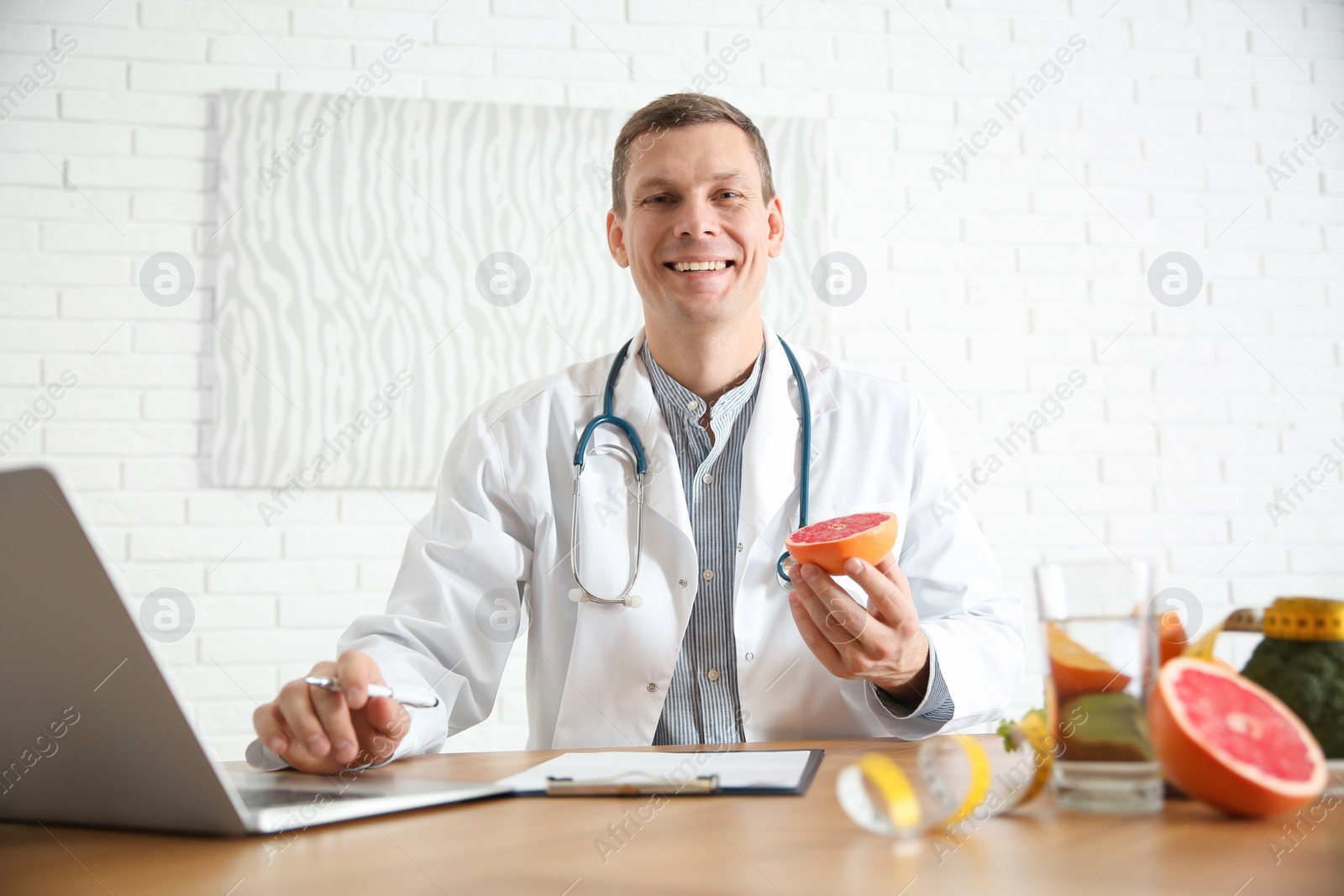 Photo of Nutritionist working with laptop at desk in office