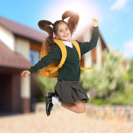 Image of Happy girl jumping near house. School holidays