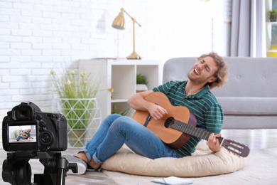 Image of Music teacher recording guitar lesson at home