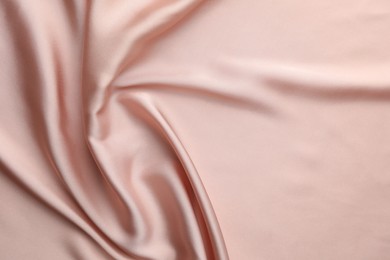 Crumpled pink silk fabric as background, top view. Space for text