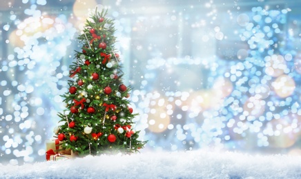 Image of Beautiful decorated Christmas tree against blurred lights, space for text. Bokeh effect