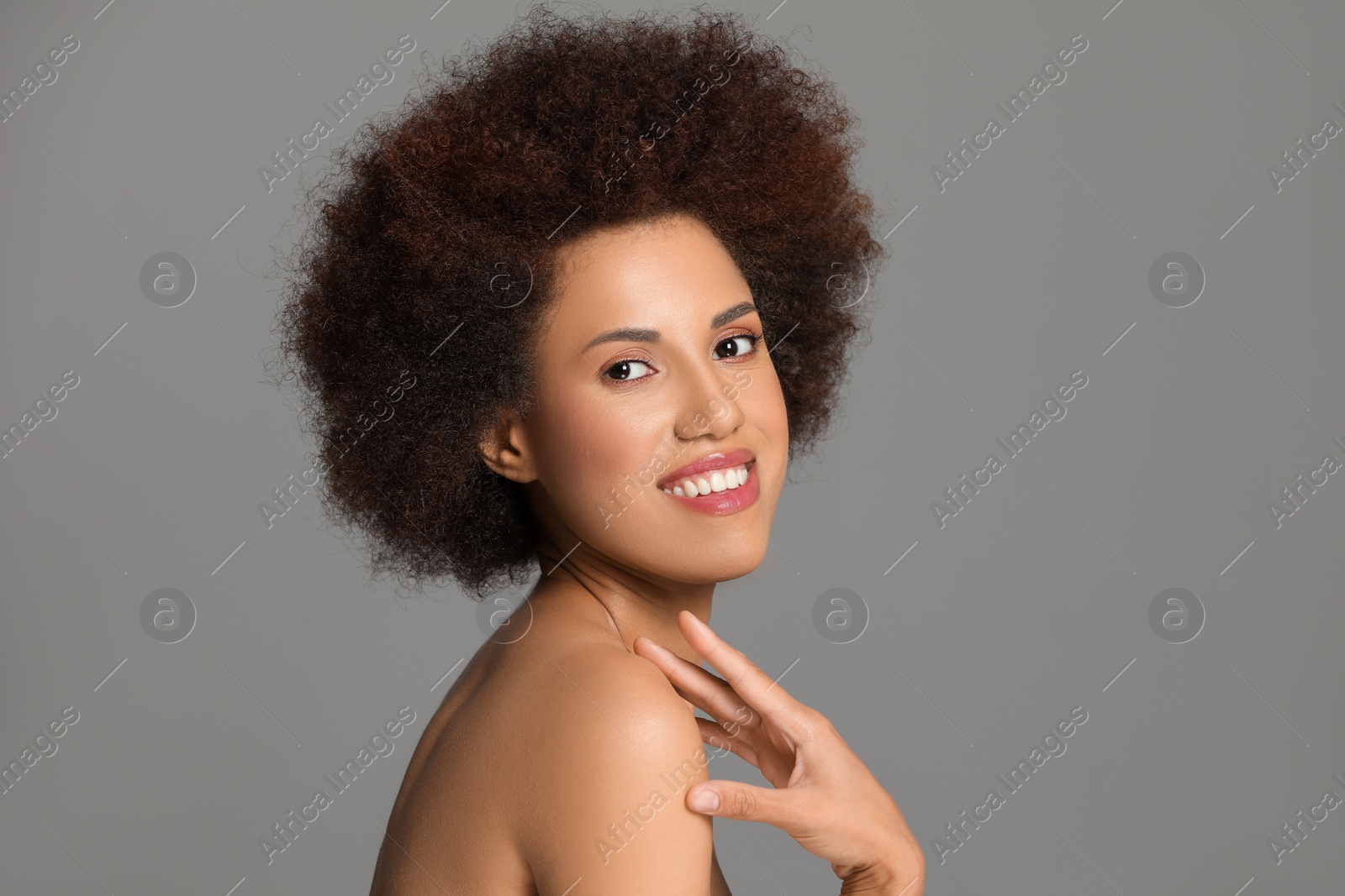 Photo of Portrait of beautiful young woman with glamorous makeup on grey background