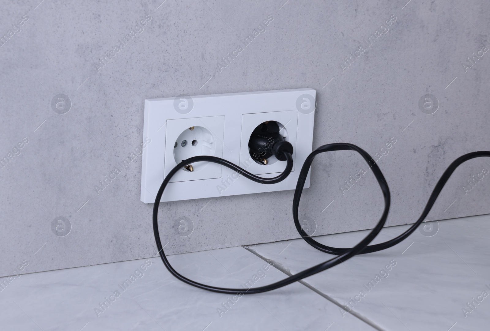 Photo of Power sockets and electric plug on grey wall