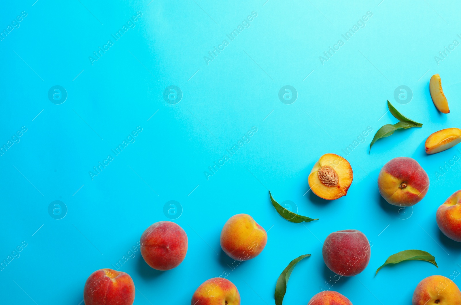 Photo of Flat lay composition with fresh peaches on blue background. Space for text