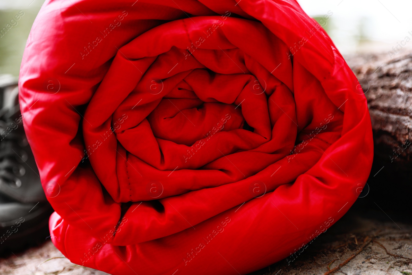 Photo of Rolled sleeping bag outdoors on sunny day, closeup