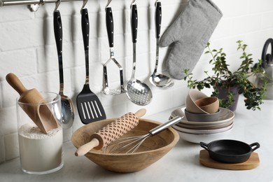 Photo of Different cooking utensils and plant on countertop in kitchen