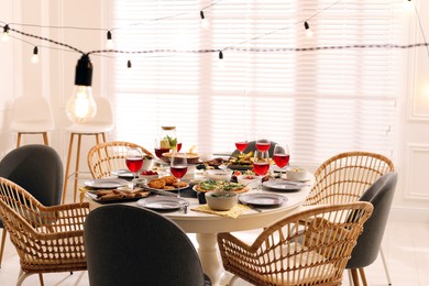 Photo of Brunch table setting with different delicious food and chairs indoors