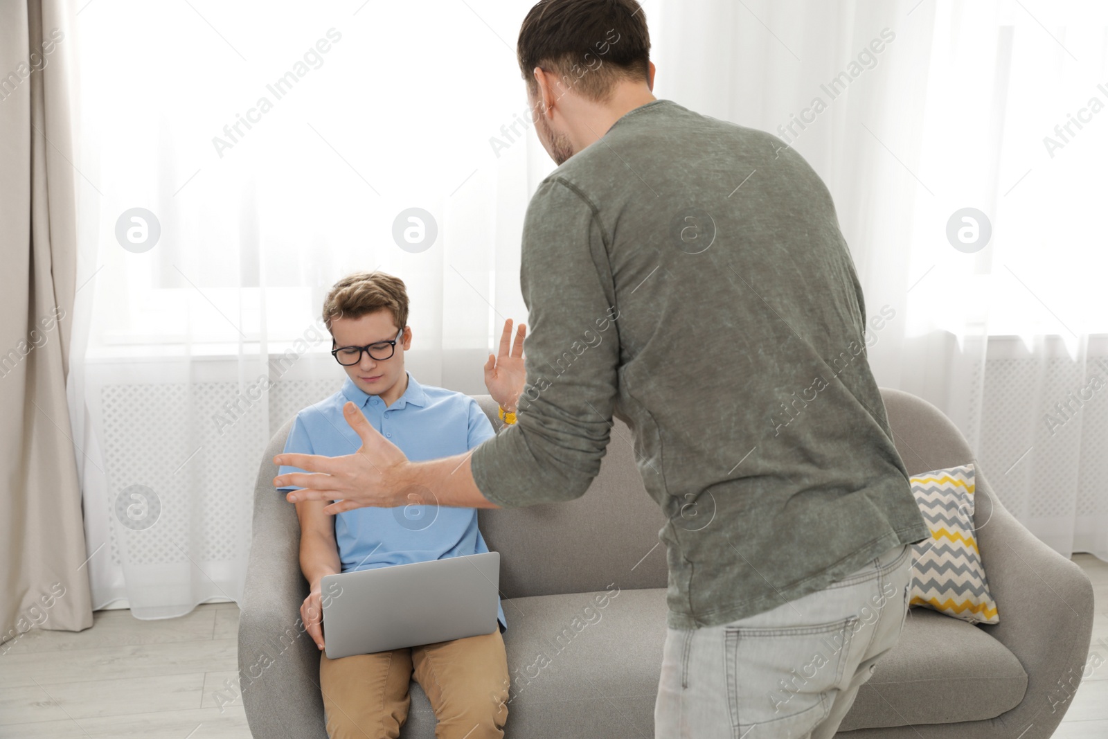 Photo of Father scolding his teenager son at home