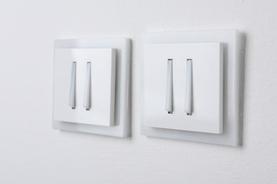 Photo of Modern light switches on white background, closeup