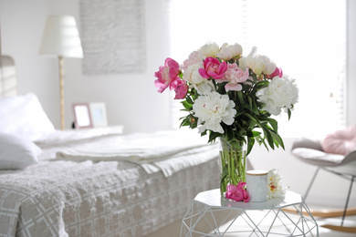 Photo of Beautiful blooming peonies on table in bedroom. Space for text