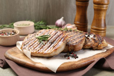 Photo of Delicious grilled pork steaks with herbs and spices on table, closeup