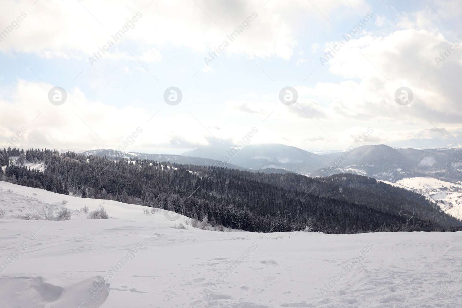 Photo of Picturesque mountain landscape with snowy hills under cloudy sky