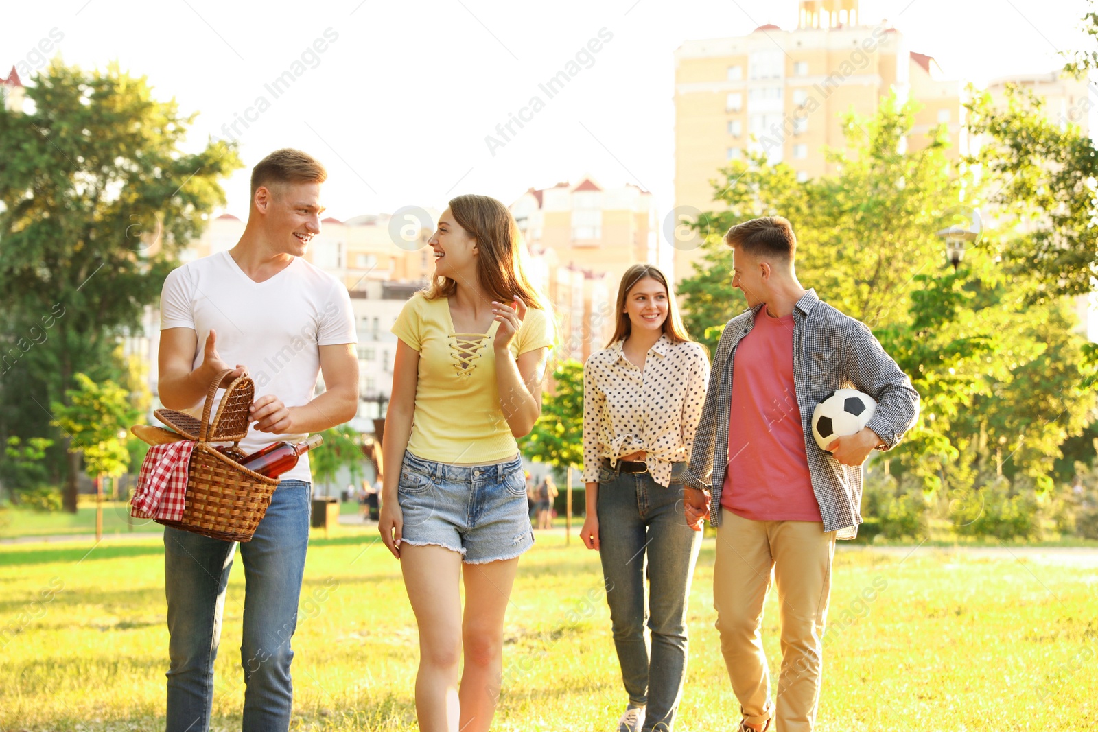 Photo of Young people with picnic basket in park on summer day