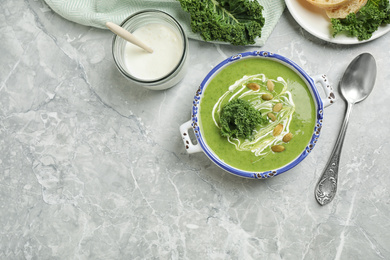 Photo of Tasty kale soup served on light grey marble table, flat lay. Space for text