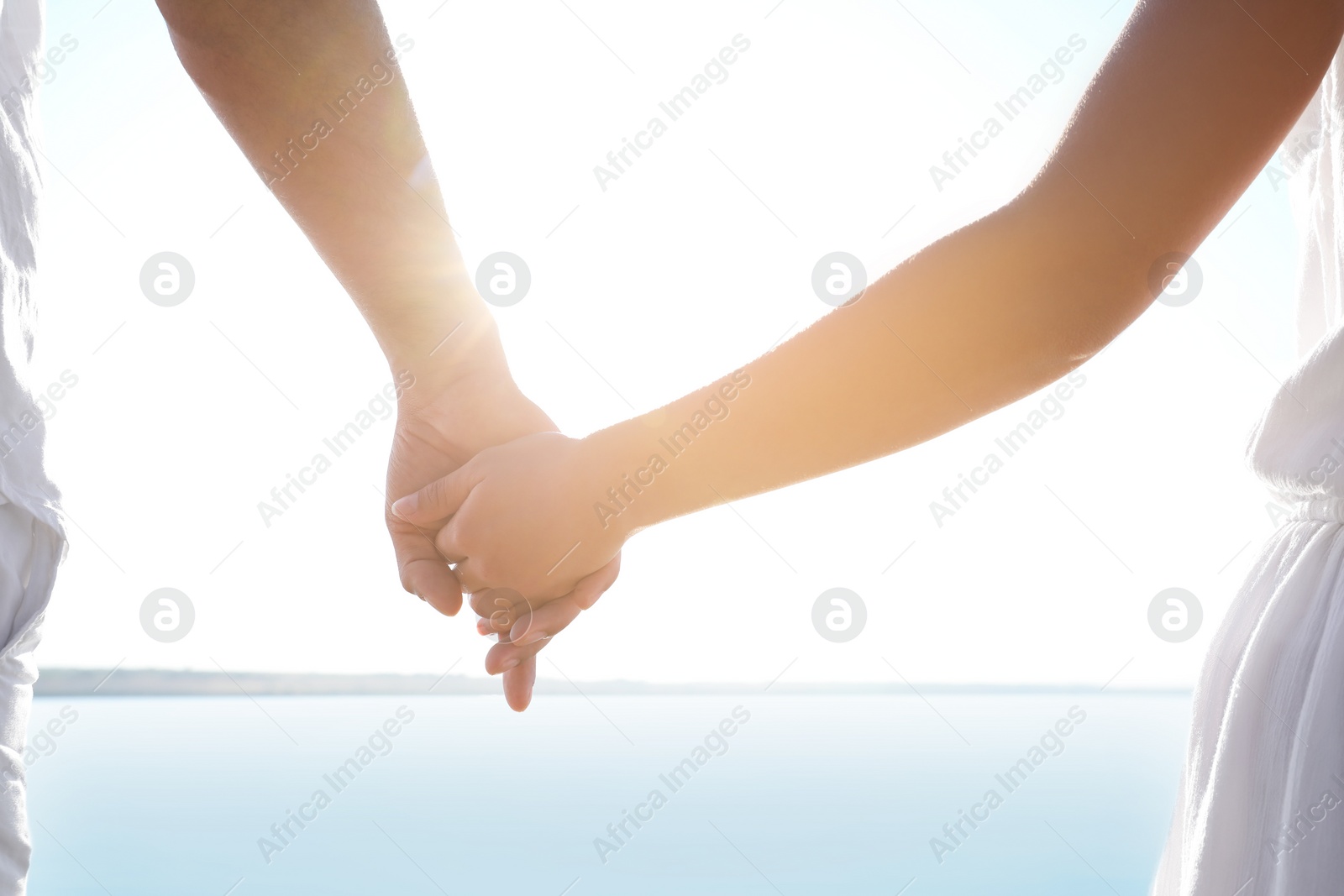 Photo of Couple holding hands together near river, closeup. Nature healing power