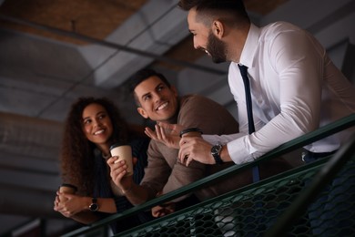 Photo of Group of coworkers talking during coffee break in office