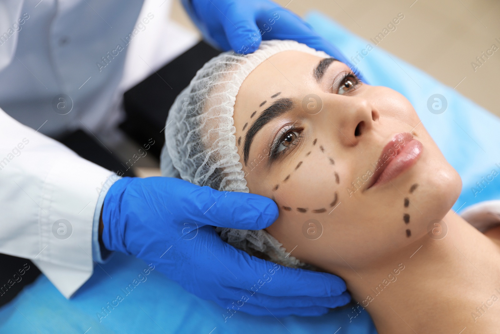 Photo of Doctor preparing female patient for cosmetic surgery in clinic