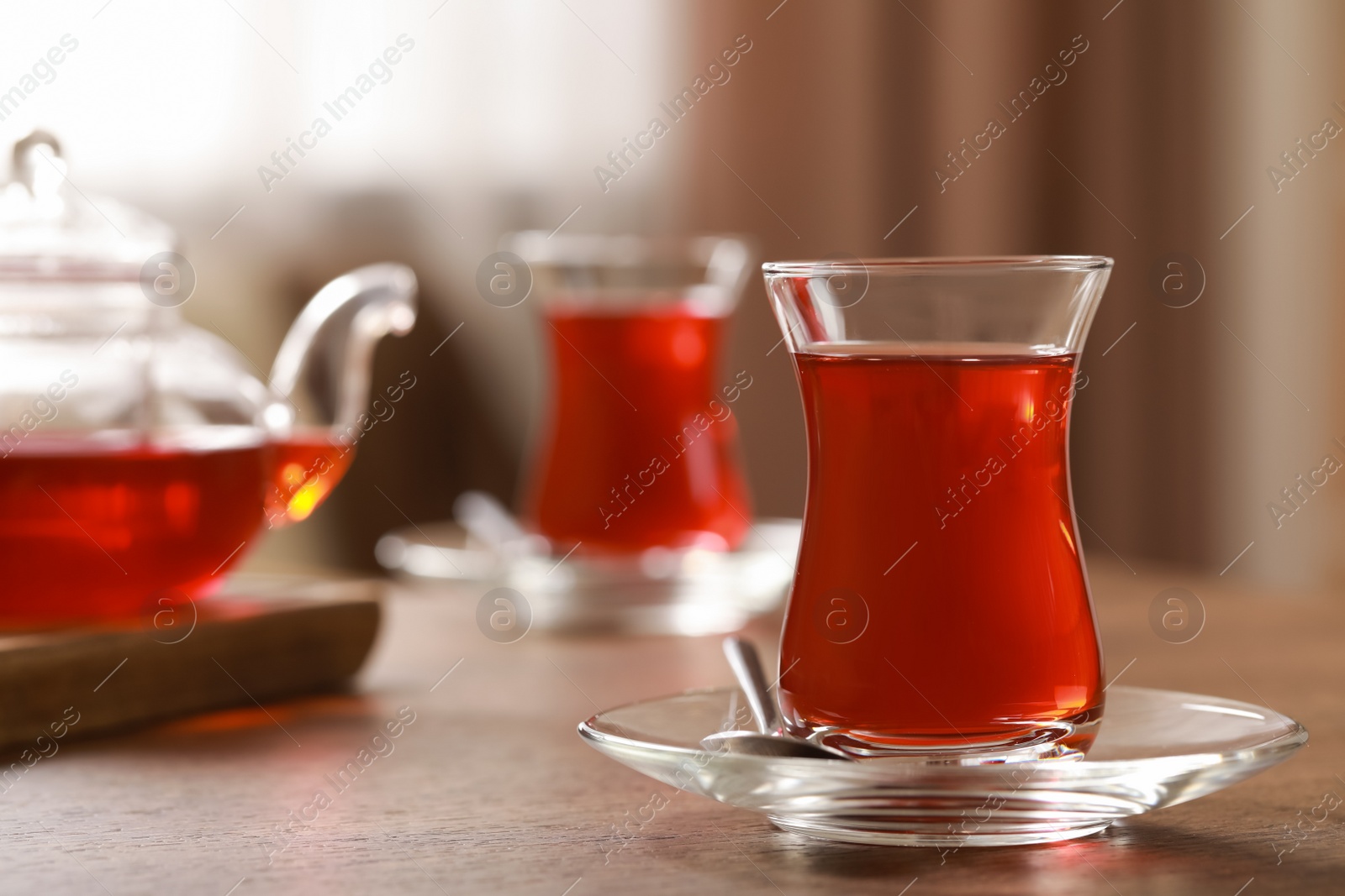 Photo of Glasses with traditional Turkish tea on wooden table, space for text