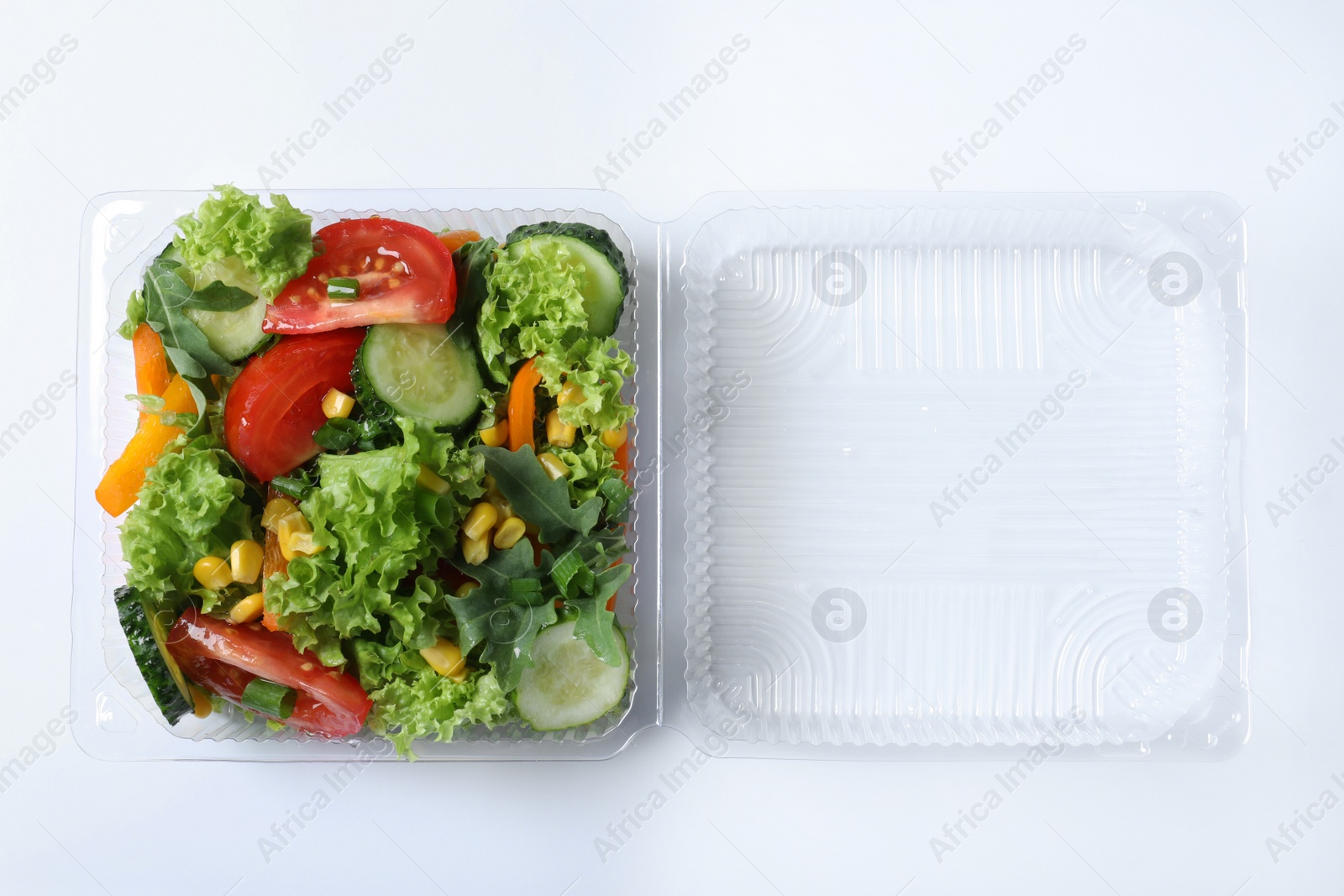 Photo of Plastic container with fresh salad on white background, top view