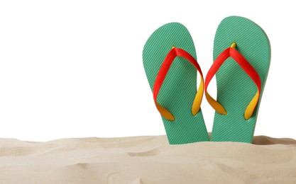 Photo of Turquoise flip flops in sand on white background
