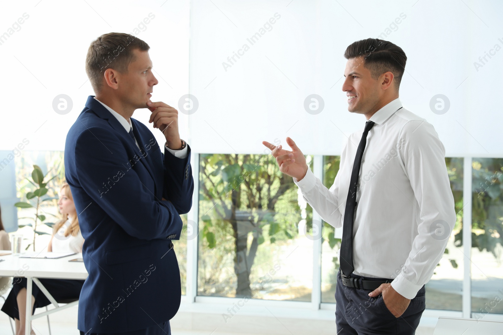 Photo of Office employees talking at workplace during break