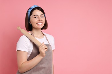 Happy confectioner with rolling pin on pink background, space for text