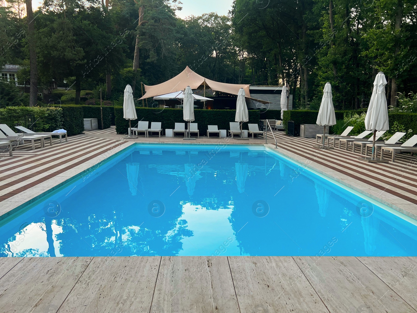 Photo of Outdoor swimming pool in luxury hotel on sunny summer day. Time for relax