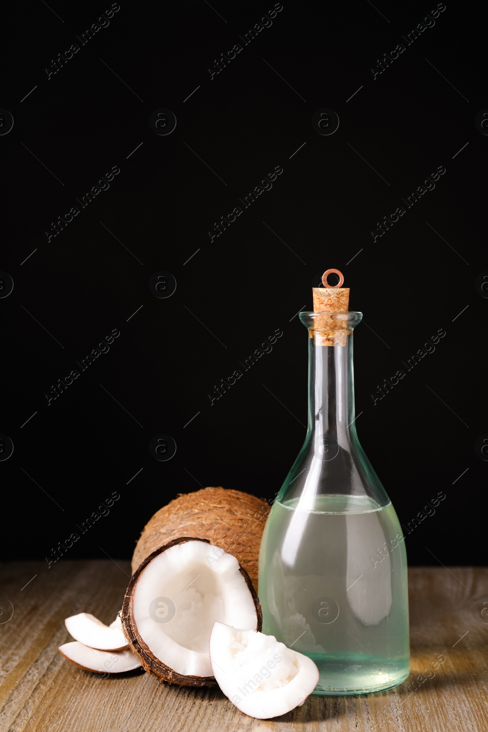 Photo of Coconut oil on wooden table against black background