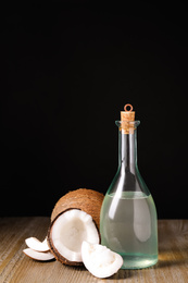 Photo of Coconut oil on wooden table against black background