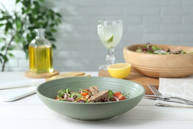 Photo of Delicious salad with beef tongue and vegetables served on white wooden table