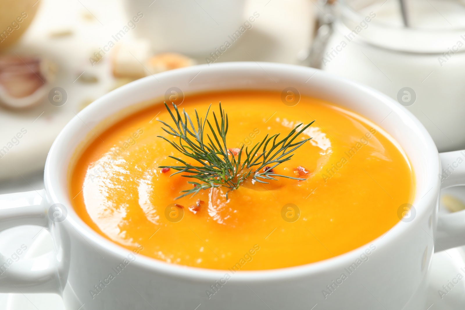 Photo of Delicious pumpkin soup in bowl on table, closeup