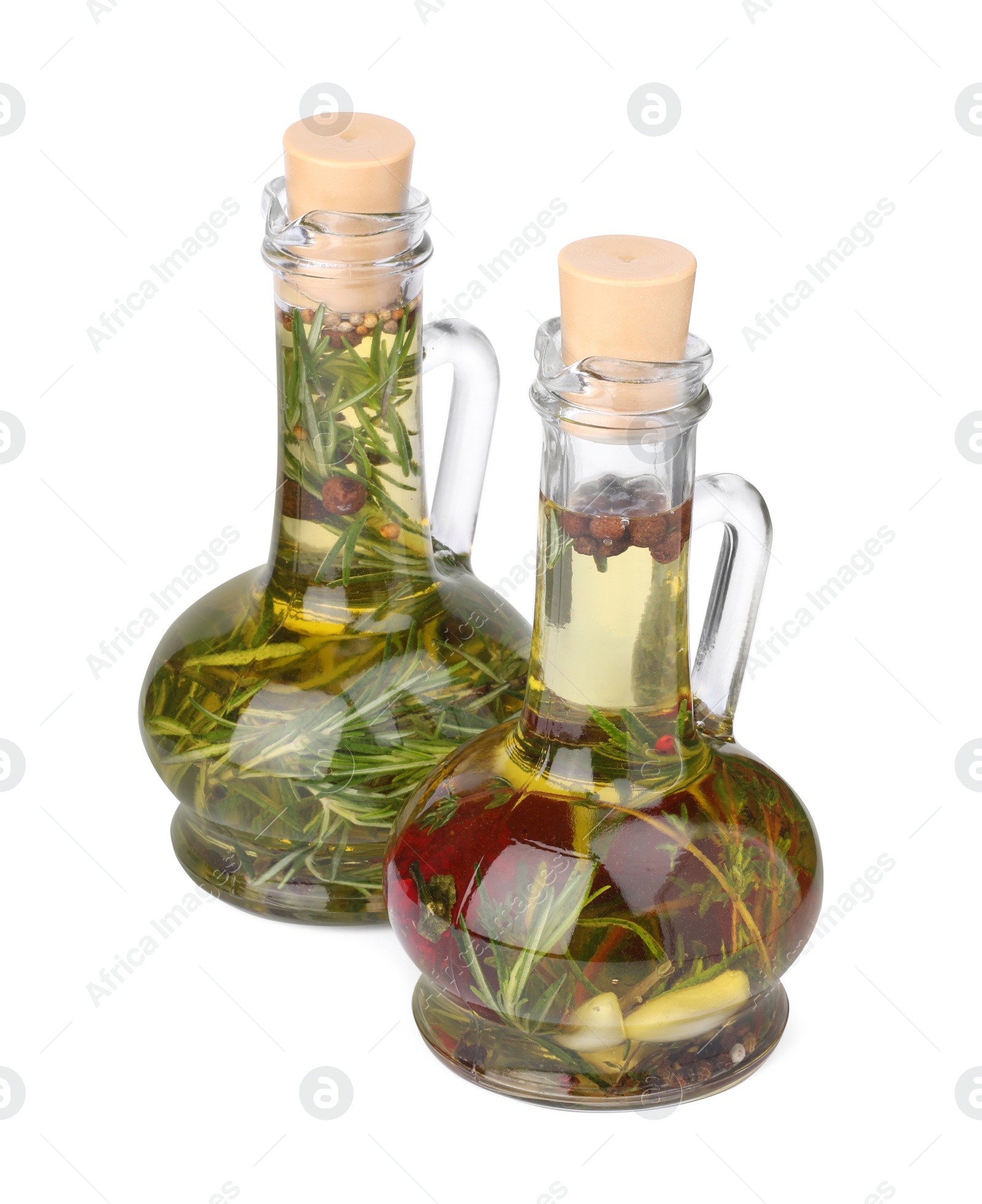 Photo of Glass jugs of cooking oils with spices and herbs on white background