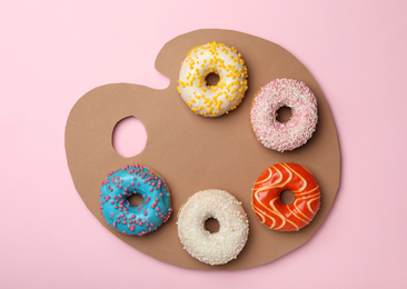 Photo of Artist's palette made with donuts and cardboard on pink background, top view