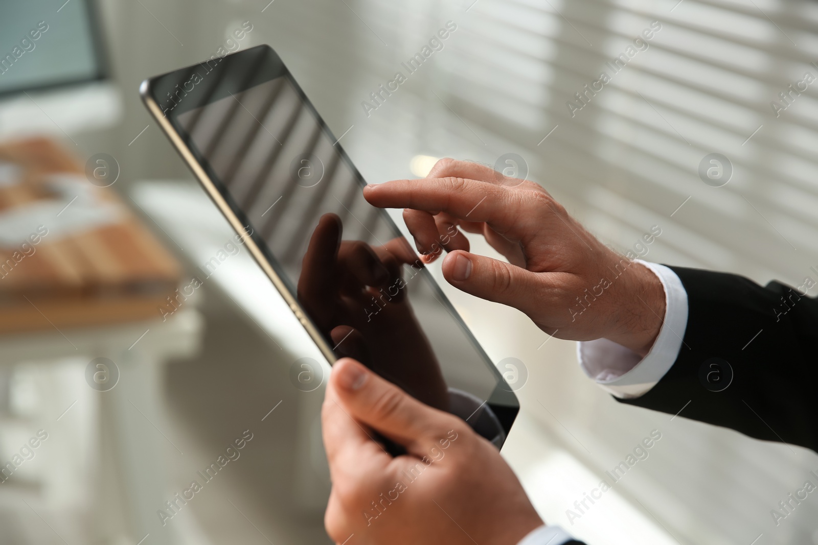 Photo of Businessman using modern tablet in office, closeup