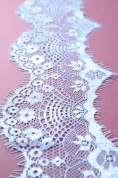 Photo of White lace on purple background, closeup view