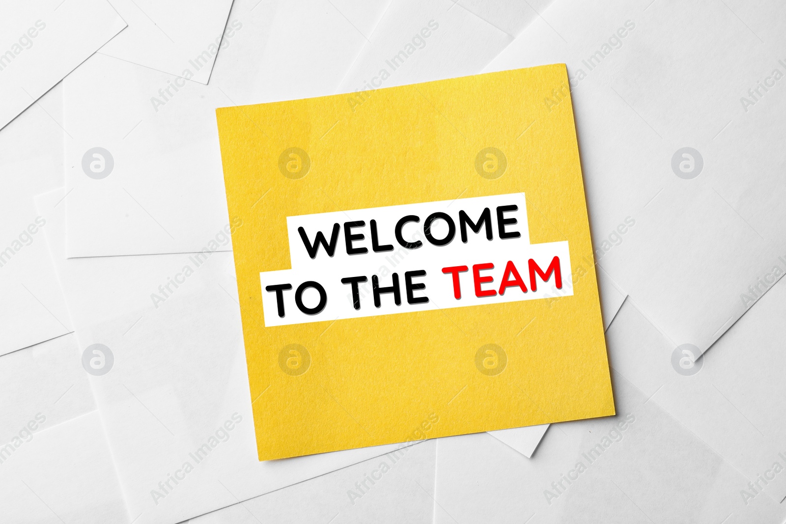 Image of Note with phrase Welcome to the team on sheets of paper, top view