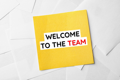 Image of Note with phrase Welcome to the team on sheets of paper, top view