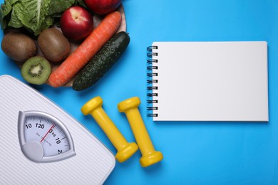 Photo of Scales, notebook, fresh fruits and vegetables on light blue background, flat lay. Low glycemic index diet