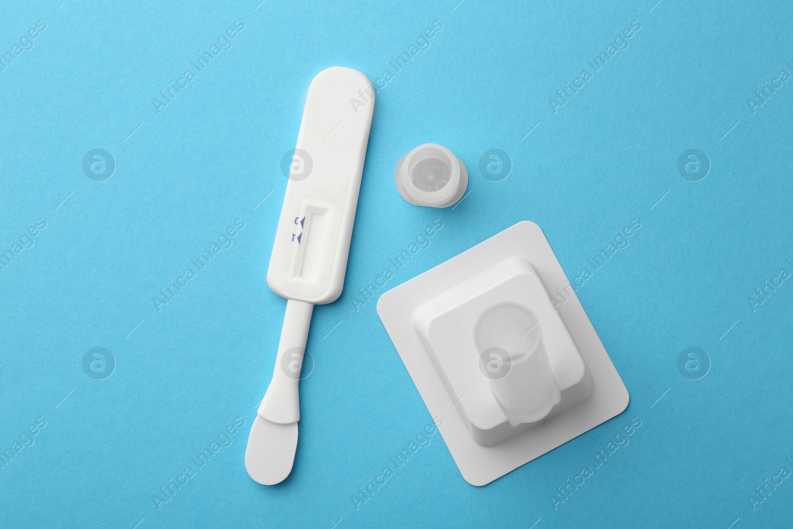 Photo of Disposable express test kit on light blue background, flat lay