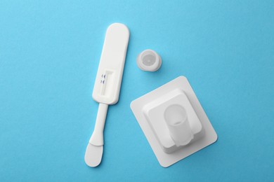 Disposable express test kit on light blue background, flat lay