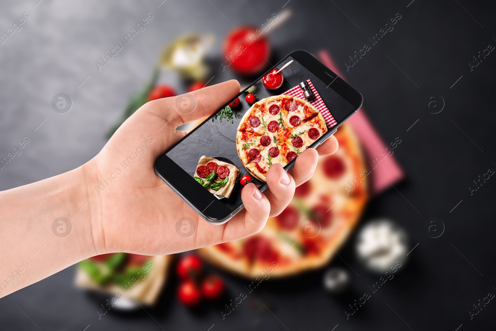 Image of Blogger taking picture of delicious pepperoni pizza at table, closeup. Food photography