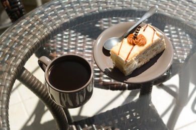 Photo of Tasty dessert and cup of fresh aromatic coffee on glass table outdoors, above view