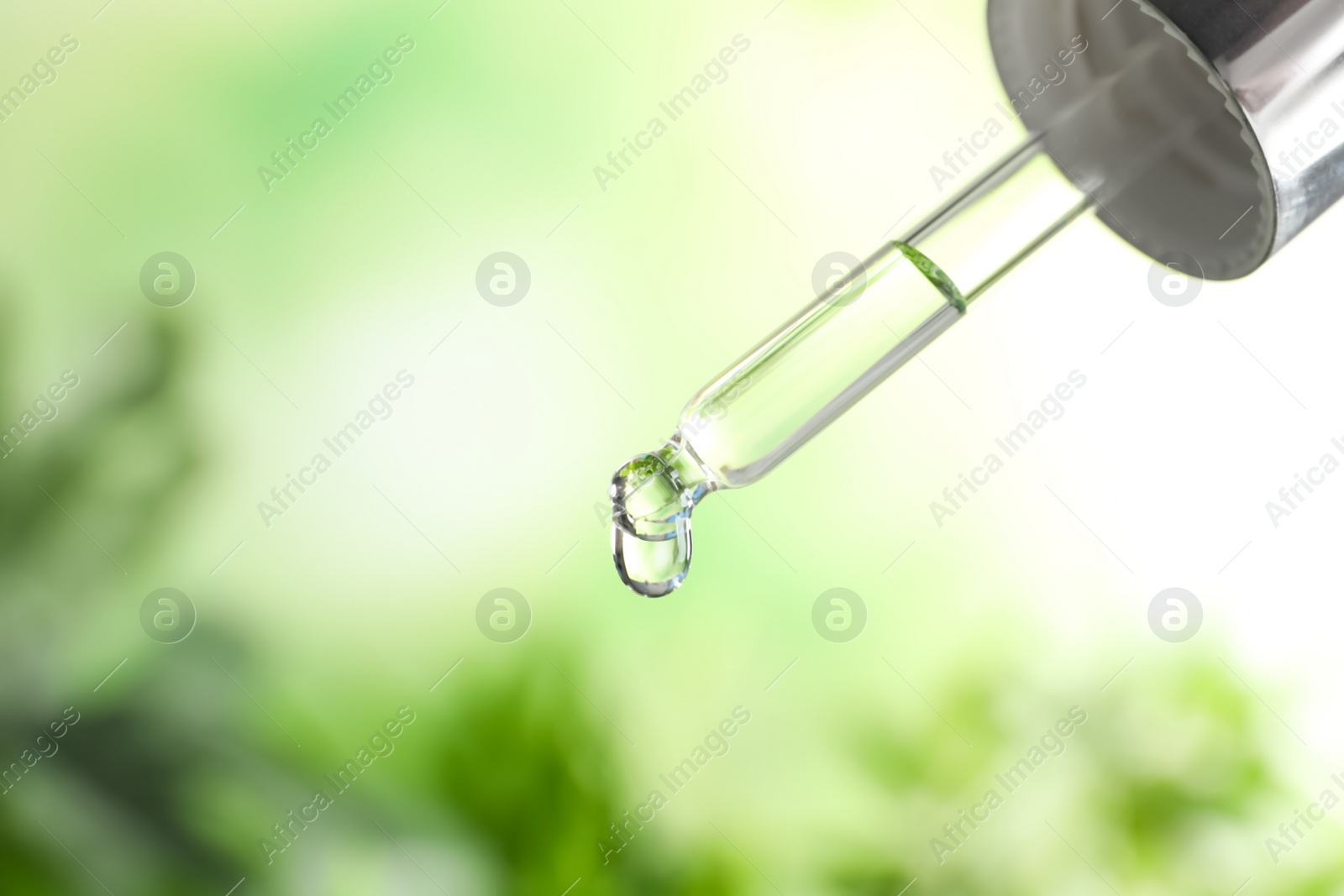 Photo of Pipette with essential oil on blurred background. Space for text